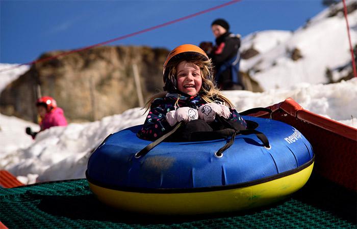 Mädchen auf aufblasbarem Reifen: alternative Möglichkeiten im Schnee